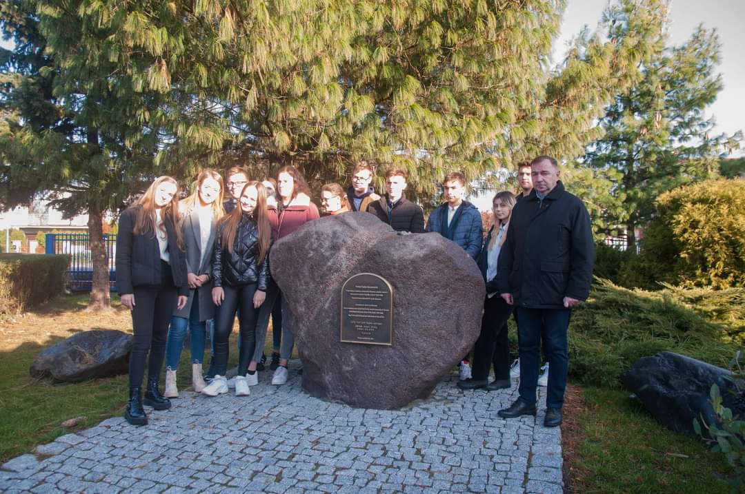 Osoby przed pomnikiem pamięci FB IMG 1636108674729