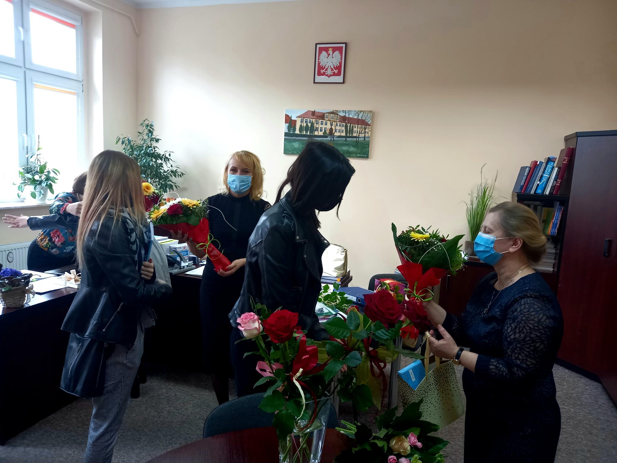 Uczniowie wręczają kwiaty